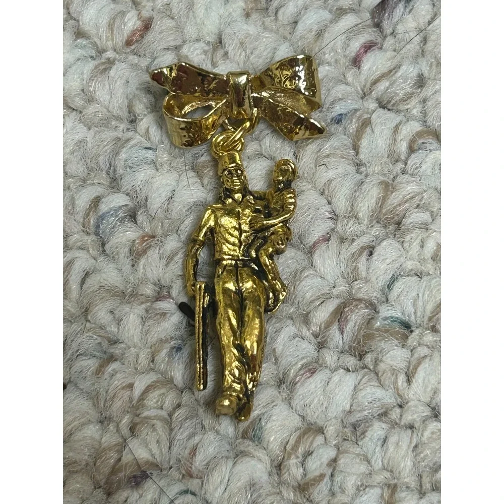 Vintage Gold Tone Soldier Carrying Child Bow Dangle Brooch Pin Commemorative